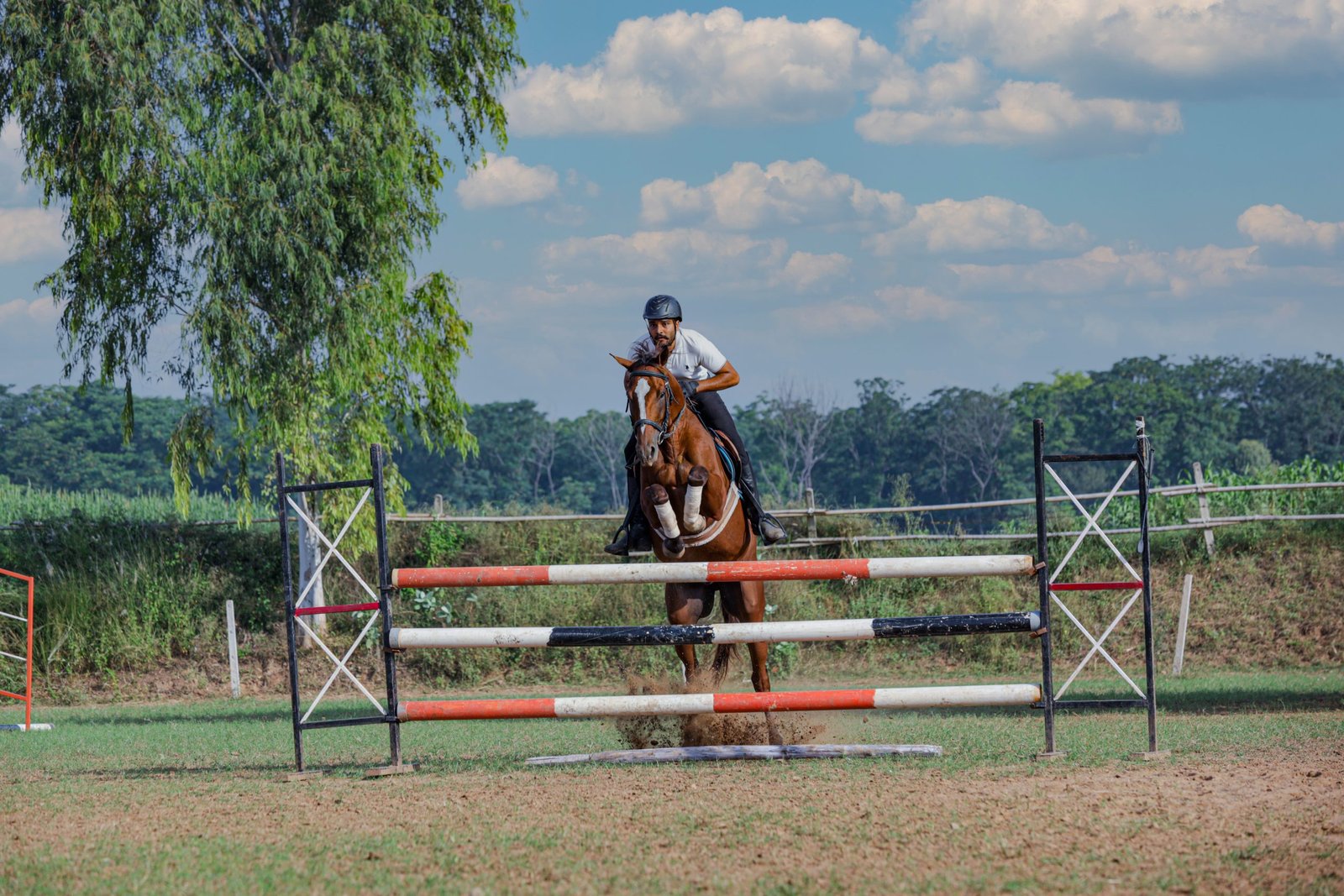 A rider clearing a fence in the estate arena